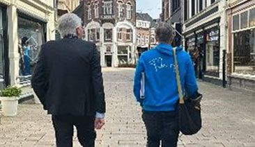 Burgemeester loop samen met vrijwilliger door de stad